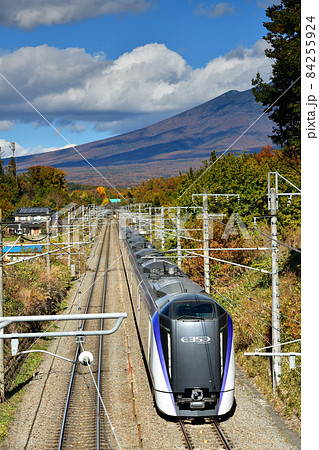 北杜市長坂町、八ヶ岳をバックに中央本線を行く上り特急列車 84255924