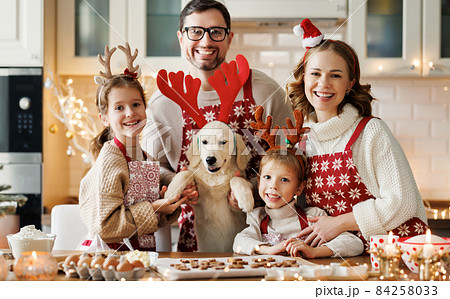 Happy family parents with two kids and golden retriever puppy while making xmas cookies at home Happy family parents with two kids and golden retriever puppy while making xmas cookies at home 84258033
