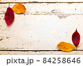 秋、紅葉した落ち葉とシャビーシックなビンテージアンティークの白いテーブル 84258646