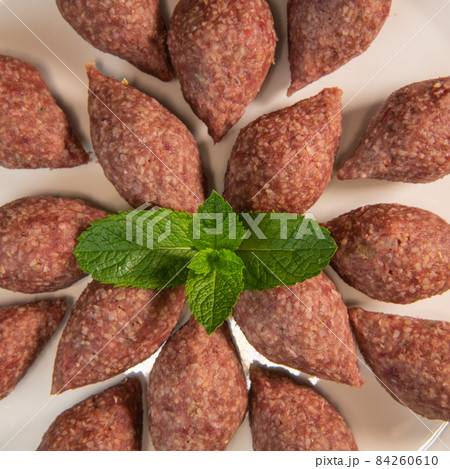 Traditional kebbe and pita bread on big round plate in lebanese restaurant Traditional kebbe and pita bread on big round plate in lebanese restaurant 84260610
