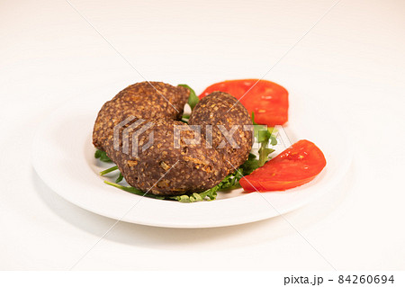 Traditional kebbe and pita bread on big round plate in lebanese restaurant Traditional kebbe and pita bread on big round plate in lebanese restaurant 84260694
