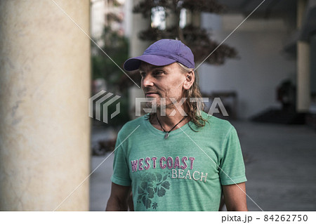 Portrait of mature man with grey hair in cap looking aside. street style portrait. High quality photo Portrait of mature man with grey hair in cap looking aside. street style portrait. High quality photo 84262750