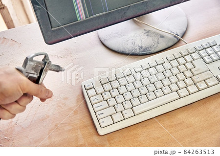 Cleaning a dusty keyboard with a compressed air gun Cleaning a dusty keyboard with a compressed air gun 84263513