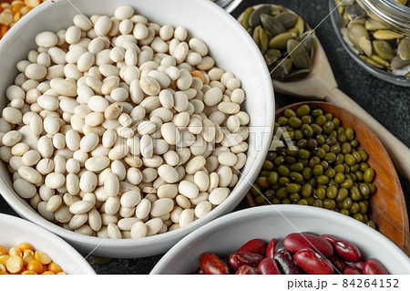 White ceramic bowls with assorted grains on kitchen table 84264152