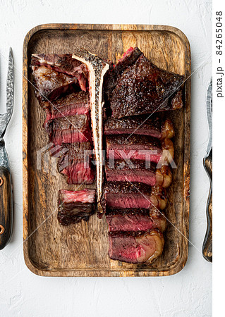Porterhouse steak is grilled sliced on a piece, on white stone background, top view flat lay 84265048
