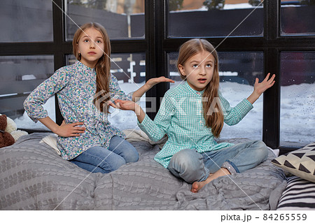 The cute little girl is snitching at her sister, pointing at her with her finger 84265559
