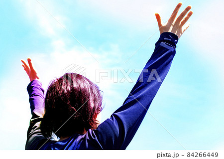 A Young Woman Is Looking Up With Her Hands Open Stock Photo