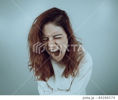 Close-up portrait of insane woman in straitjacket on white background. 84266574