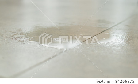 Water drips onto the tiled floor. 84266575