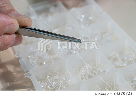 Installation of nose pads in glasses. A male technician repairs broken glasses Installation of nose pads in glasses. A male technician repairs broken glasses 84270723