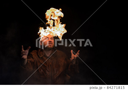 Bald man in a leather jacket with a burning head on a dark background. Bald man in a leather jacket with a burning head on a dark background. 84271815