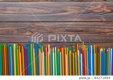 Heap of colorful plastic drinking straws on Colored background, flat lay. Copy Space for text 84271894