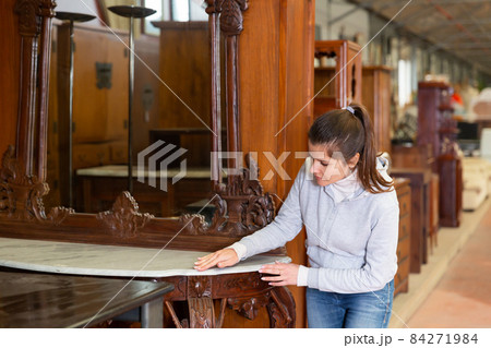 Satisfied woman chooses new furniture for home in the store 84271984