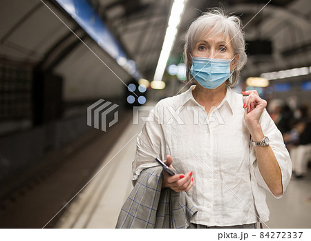 Senior woman in face mask waiting in subway station Senior woman in face mask waiting in subway station 84272337