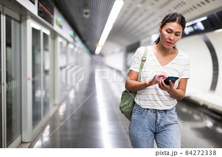 Woman using smartphone in subway station Woman using smartphone in subway station 84272338