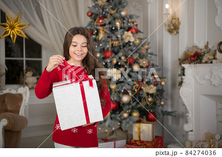 little child girl likes xmas present. The morning before 84274036