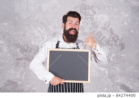 Man good looking hospitable restaurant waiter with blackboard copy space, recommend concept 84274400