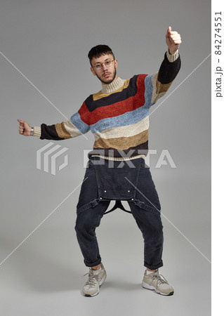 Full-length portrait of a funny guy dancing in studio on a gray background. Full-length portrait of a funny guy dancing in studio on a gray background. 84274551