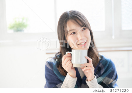 新居の様な白い部屋でコーヒーを飲みながらくつろぐ美しい日本女性　コピースペースあり	 84275220