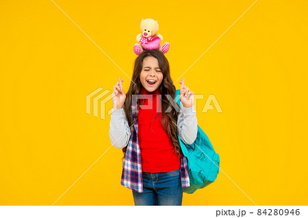 glad kid has long curly hair carry school backpack hold toy on yellow background, school 84280946