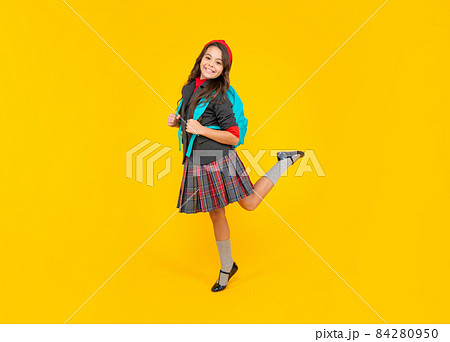 happy kid in school uniform and backpack jump on yellow background, school 84280950