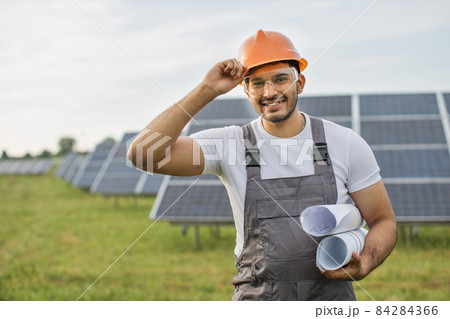 Indian technician in helmet posing at solar station Indian technician in helmet posing at solar station 84284366