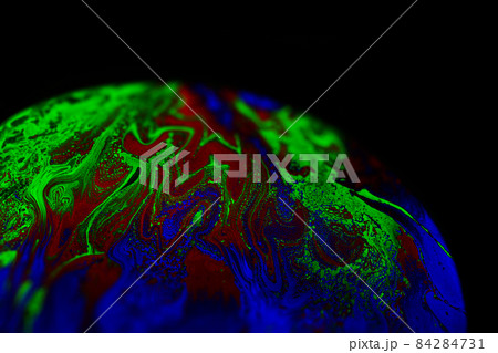 Virtual reality space with abstract multicolor psychedelic planet. Closeup Soap bubble like an alien planet on black background. 84284731