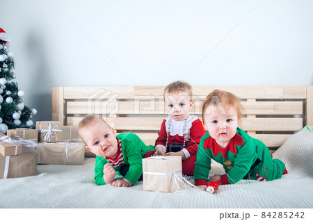 Children dressed as Santa Claus and Elves with Christmas gifts. Baby in suits for New Year.. Children dressed as Santa Claus and Elves with Christmas gifts. Baby in suits for New Year.. 84285242