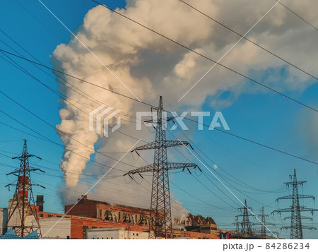 Huge clouds of smoke from chimneys, pipes of a thermal power plant, polluting the atmosphere 84286234