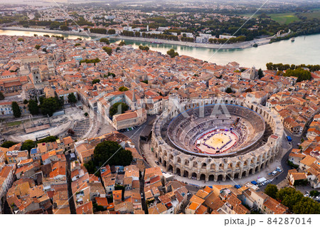 Aerial view of Arles on Rhone river overlooking Roman amphitheatre, France 84287014