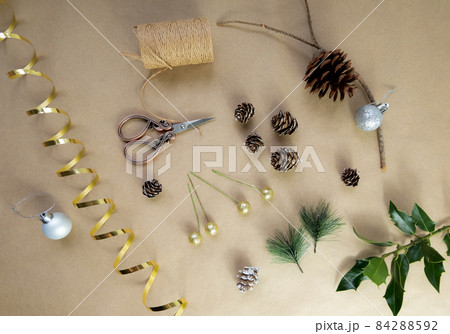 Christmas do it yourself flatlay materials pine cone, branch, beads, scissors, ribbon, thread, eco-friendly accessories for handmade home holiday decor, simple objects, selective focus Christmas do it yourself flatlay materials pine cone, branch, beads, scissors, ribbon, thread, eco-friendly accessories for handmade home holiday decor, simple objects, selective focus 84288592