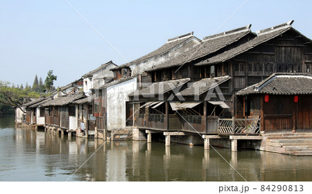 Wuzhen Water Town, Zhejiang Province, China. Traditional wooden houses beside a canal in the old Chinese town of Wuzhen. Wuzhen Canal Town is also known as the Venice of the East. 84290813