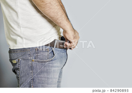 A man with erectile dysfunction looking into his jeans waiting for any reaction. Concept of mens sexual health, impotence. Man having erectile problems. A guy looking in his pants 84290893