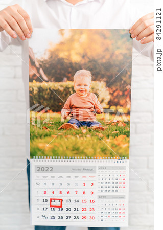 men's hands hold calendar with photo of child in front of. printed products men's hands hold calendar with photo of child in front of. printed products 84291121