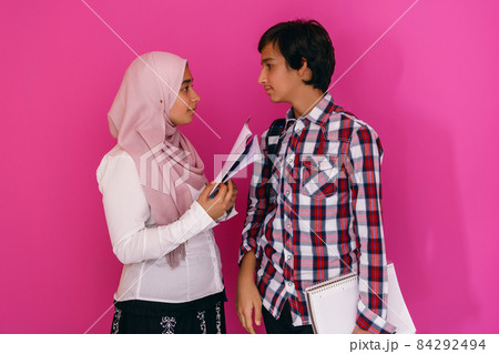 Arabic teenagers group, students team walking forward in future and back to school concept pink background. Selective focus  84292494