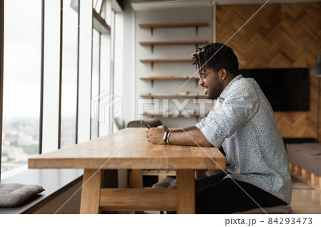 Happy millennial african american man using smartphone. 84293473