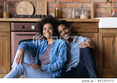 Portrait of smiling young African couple resting in kitchen. 84293475