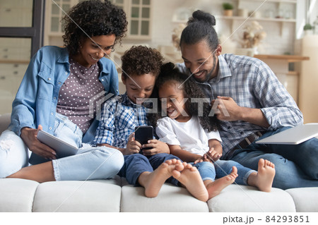 Happy family couple, little son and daughter using digital gadgets Happy family couple, little son and daughter using digital gadgets 84293851