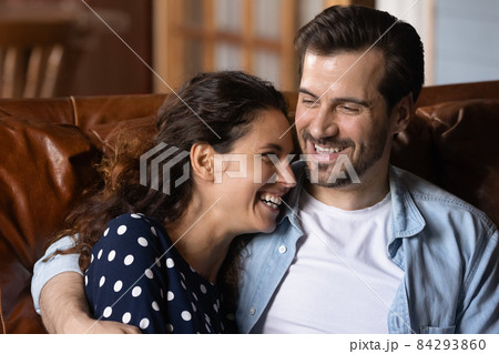 Tender millennial husband smiling clasping to chest beloved laughing wife 84293860
