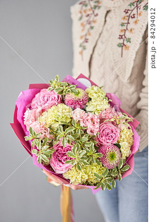 Beautiful bouquet of mixed flowers in woman hand. Handsome fresh bouquet. Small flower shop and Flowers delivery. Beautiful bouquet of mixed flowers in woman hand. Handsome fresh bouquet. Small flower shop and Flowers delivery. 84294012