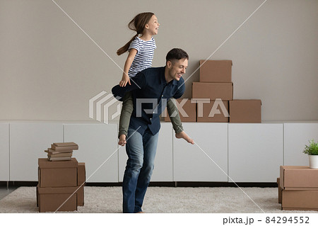 Excited father piggy backing daughter, rejoicing relocation in new home Excited father piggy backing daughter, rejoicing relocation in new home 84294552