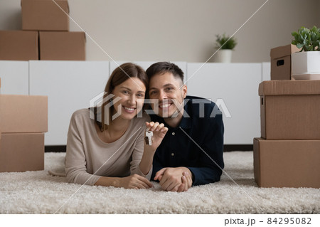 Portrait of happy couple showing key, excited by relocation Portrait of happy couple showing key, excited by relocation 84295082