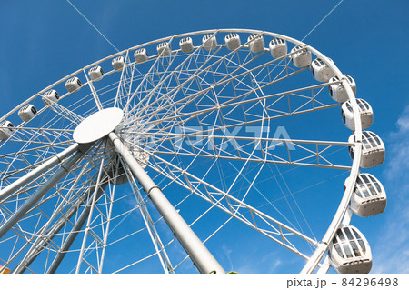 modern white ferris wheel against blue sky background 84296498