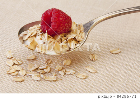 spoon of cereal with raspberry spoon of cereal with raspberry 84296771