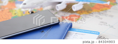 Smartphone with passport and tickets and an airplane lie on geographic map closeup Smartphone with passport and tickets and an airplane lie on geographic map closeup 84304903