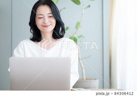 俯きパソコンで仕事をする美しいアラフォーの日本人女性 コピースペースあり 84306412