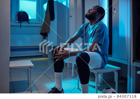 African football player in sports uniform touching knee in pain 84307118