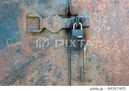 Closed old rusty metal door with lock Closed old rusty metal door with lock 84307405