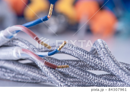 Braided textile electrical cable with colorful blurred background Braided textile electrical cable with colorful blurred background 84307961