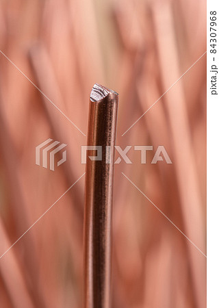 Close-up of pure single copper wire rod on blurred background, raw materials metals industry concept  84307968